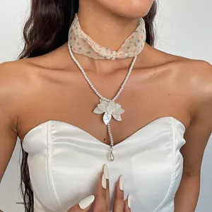 Close-up of elegant double-layered pearl and floral choker necklace on model