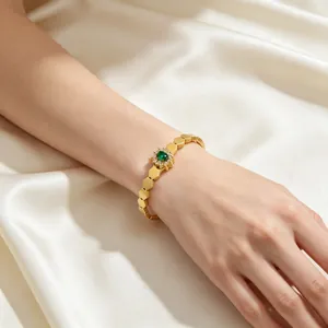 Vue détaillée d'un bracelet tournesol vintage avec pierre ovale verte sur tissu de soie