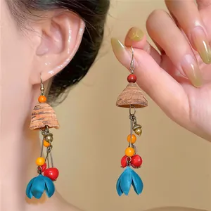 Macro detail view of ethnic style wooden flower drop earrings with colorful beads