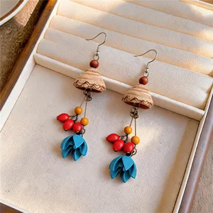 Close-up detail of ethnic wood earrings with blue flower pendants in a jewelry box