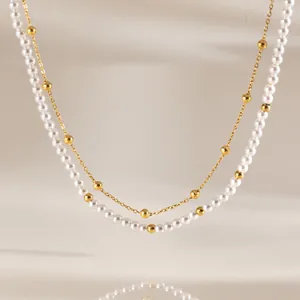 Detailansicht der zweilagigen Halskette mit 18k Goldperlen und weißen Acrylperlen