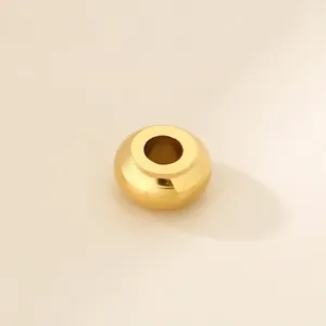 Macro detail of a polished gold stainless steel large hole abacus spacer bead.