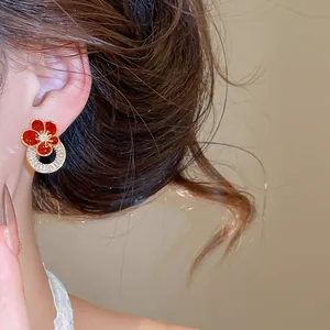 Vue détaillée d'une boucle d'oreille fleur en émail rouge plaquée or 18 carats et oxydes