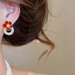 Vue détaillée de boucles d'oreilles fleur en émail rouge plaqué or 18K et zircons