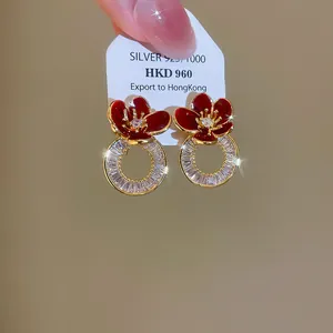 Détail des boucles d'oreilles fleurs en émail rouge plaquées or 18K avec zircons