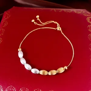 Elegant adjustable 18k gold plated bracelet with textured oval beads on a red jewelry box