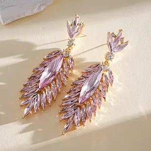 Detailopname van elegante roze kristallen bladoorbellen met goudkleurige accenten.