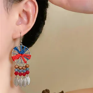 Detailansicht ethnischer Boho-Ohrringe mit bunten Fäden, Perlen und Blattquasten
