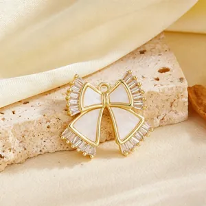 Close-up van elegante vergulde strikhanger met witte inleg en fonkelende kristallen.