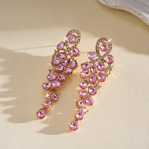 Gedetailleerd beeld van luxe roze zirkonia oorbellen met elegante gouden afwerking design