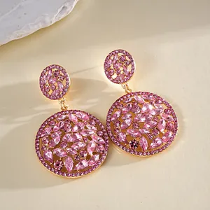 Gedetailleerde macro-opname van elegante roze strass hangende oorbellen met gouden laag