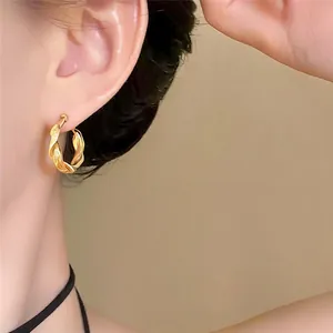Detailansicht eleganter goldener gedrehter Creolen für einen minimalistischen Stil