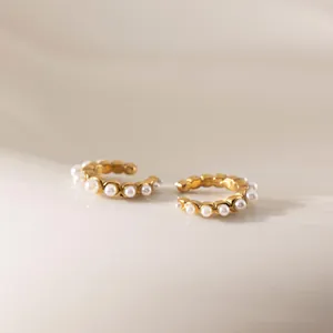 Dettaglio di orecchini ear cuff in acciaio inossidabile placcato oro 18k con perle