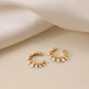 Primo piano di ear cuff in acciaio inossidabile dorato 18k con perle bianche