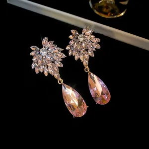 Gedetailleerde weergave van elegante roze druppeloorbellen met zirkoon bloemclusters