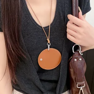 Macro view of a tan leather circular pendant used as a fashion glasses holder.