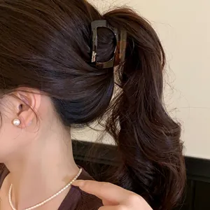 Gros plan d'une pince à cheveux élégante en acrylique écaille de tortue sur cheveux
