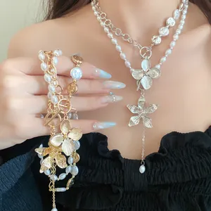 Detailansicht einer eleganten Perlenkette mit Metallblumenanhänger und OT-Verschluss
