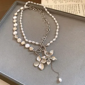 Elegante Nahaufnahme einer zweilagigen Perlenkette mit silbernen Blumenanhängern und OT-Verschluss
