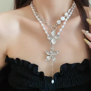 Elegante doppelschichtige Perlenkette mit einem detaillierten silbernen Blumenanhänger.