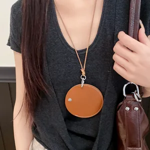 Leather cord necklace with a round tan pendant used as a stylish glasses holder