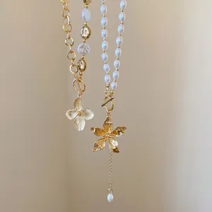 Detailansicht von Perlenketten mit filigranen Goldblumenanhängern und schicken OT-Verschlüssen