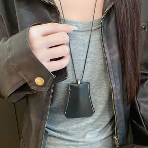Close-up of black leather trapezoidal pendant necklace with white contrast stitching