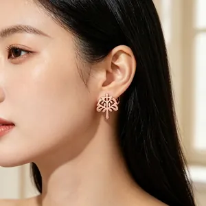 Detailansicht der eleganten, hohl geschnittenen Lebensbaum-Ohrstecker in Roségold an einem Model.
