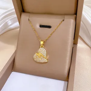 Detail van gouden hartketting met bliksem en kristallen in een doosje
