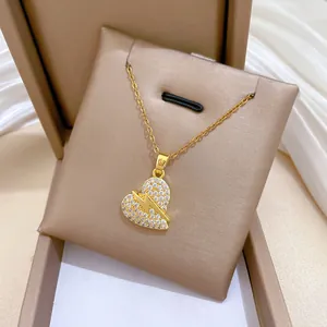 Nahaufnahme eines goldenen Herzanhängers mit Kristall-Pavé und Blitz-Detail.