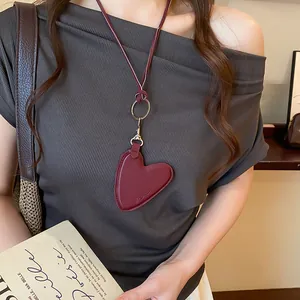 Vue détaillée d'un collier avec pendentif cœur en cuir rétro sur un haut marron