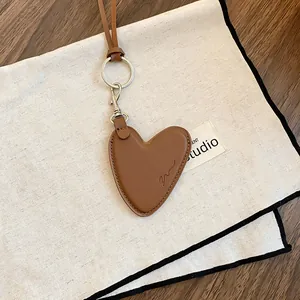 Gros plan d'un pendentif en forme de cœur en cuir marron vintage avec fermoir en métal