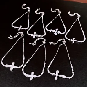 Detailed view of silver cross bracelets with sparkling zircon charms and adjustable pull-ties.