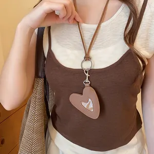 Gros plan d'un collier pendentif cœur en cuir marron vintage porté par un mannequin.