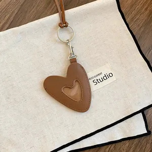 Vue détaillée d'un pendentif cœur en cuir marron vintage avec fenêtre transparente