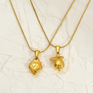 Close-up of gold-plated stainless steel strawberry and lemon fruit pendants on necklaces