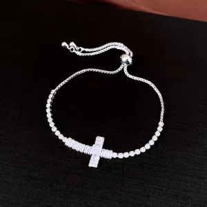 Close-up of adjustable silver bracelet with sparkling zircon cross pendant
