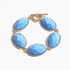 Elegant gold-tone vintage bracelet featuring five faceted oval blue resin stones
