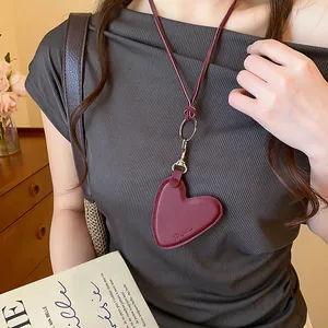 Gros plan détaillé d'un collier avec pendentif cœur en cuir bordeaux vintage pour femme