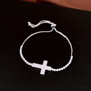 Detailed close-up view of a silver-toned zircon encrusted cross adjustable slider bracelet