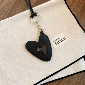 Gros plan d'un pendentif en cuir noir en forme de cœur avec un clip métallique argenté