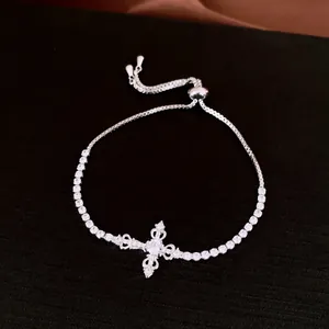 Detailed view of silver cross pendant bracelet with cubic zirconia and slider