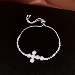 Detailed macro view of silver zircon cross pendant on an adjustable bolo bracelet.