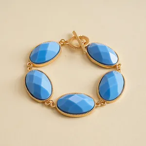 Detailed close-up view of a vintage gold-tone bracelet featuring blue oval resin stones