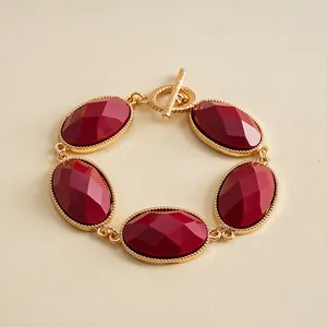 Elegant vintage gold-toned toggle bracelet featuring five faceted oval red resin stones