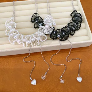 Detailopname van Franse vintage kralen kant kettingen met parels en hartjes hangers