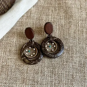 Detailansicht von böhmischen Ethno-Ohrringen im Vintage-Stil aus Holz und Muschelmaterial.