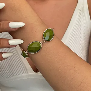 Vintage olive green resin oval link bracelet with gold metal frame shown on wrist