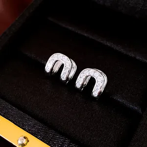 Detailed macro shot of silver-tone zircon pavé hollow hoop earrings in a black gift box