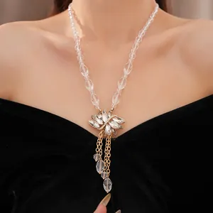 Elegante glazen kralenketting met kristallen bloemenhanger en goudkleurige kwastjes.